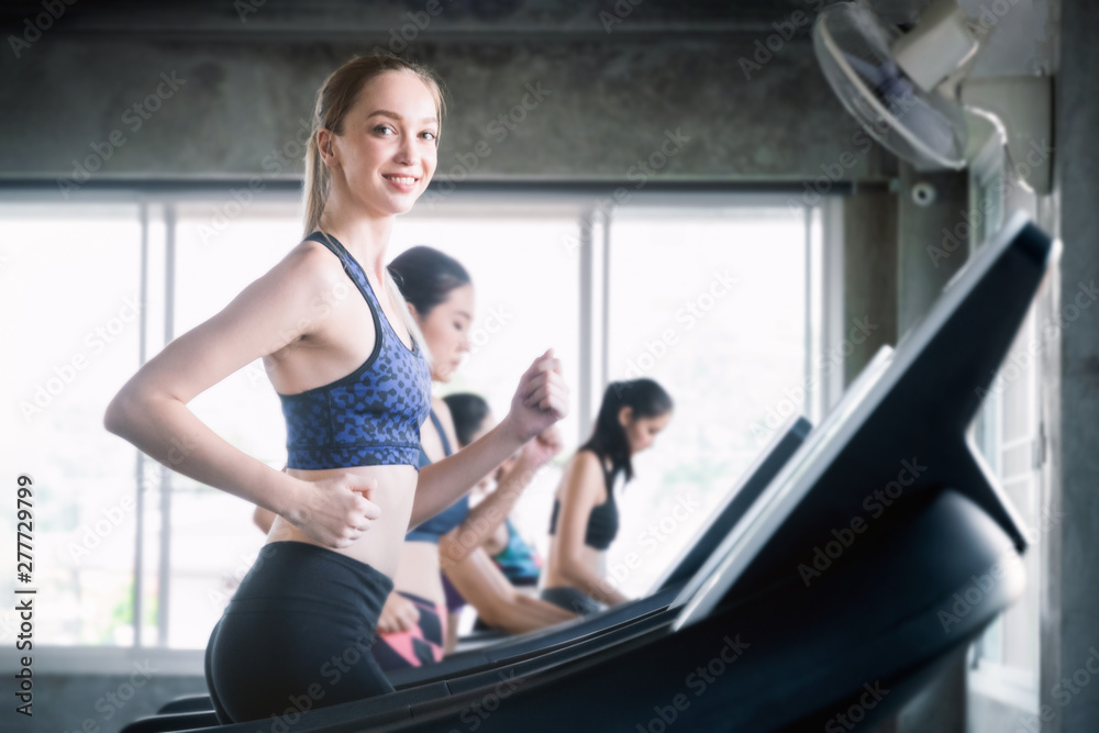 Closed up happy young woman with smile is running on a treadmill in the gym, Sport and healthy concept. Closed up happy young woman with smile is running on a treadmill in the gym, Sport and healthy concept.