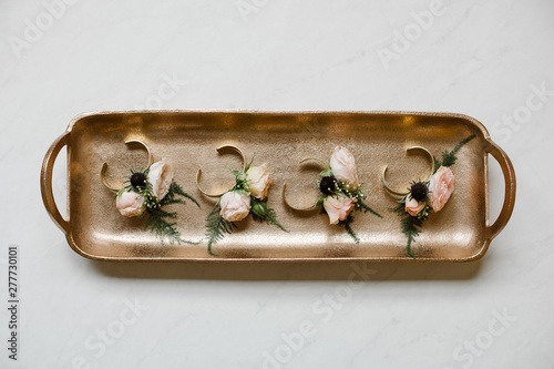 a tray of winter wedding corsages on marble 