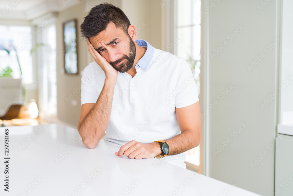 Handsome hispanic man casual white t-shirt at home thinking looking tired and bored with depression problems with crossed arms.