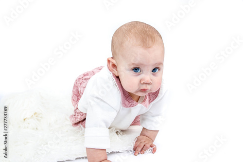 Sweet Baby girl in pink, starting to crawl on a true white studio backdrop