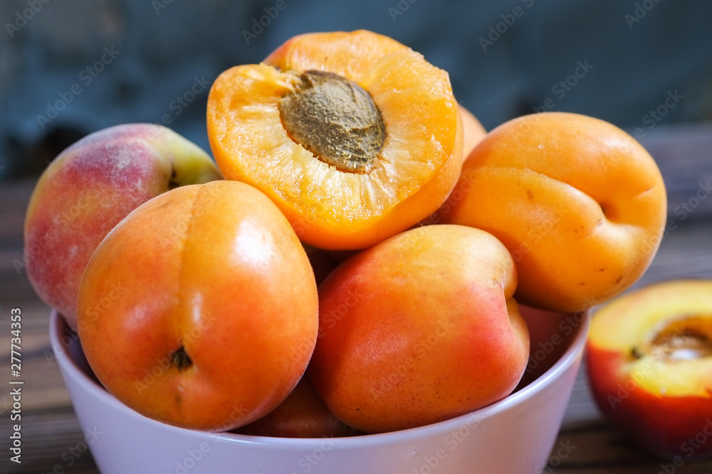 apricots in bowl on wooden table. Close up, selective focus. apricots in bowl on wooden table. Close up, selective focus.