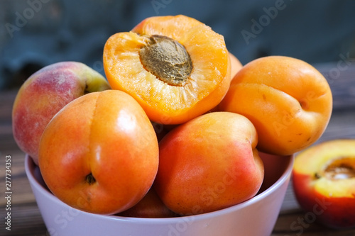 apricots in bowl on wooden table. Close up, selective focus.