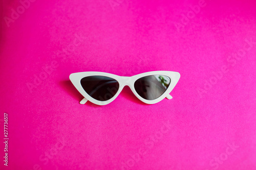 white women's sunglasses Glasses in the form of cat's eyes on a pink background