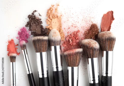Obraz Creative concept beauty fashion photo of cosmetic product make up brushes kit with smashed lipstick eyeshadow on white background.