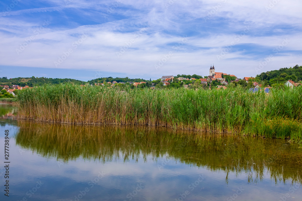 Tihany abbey at lake Balaton from the inner laker with reed and reflection on the water Tihany abbey at lake Balaton from the inner laker with reed and reflection on the water