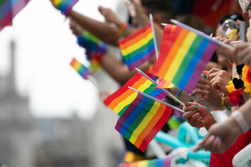 Gay pride, LGBTQ rainbow flags being waved in the air at a pride event
