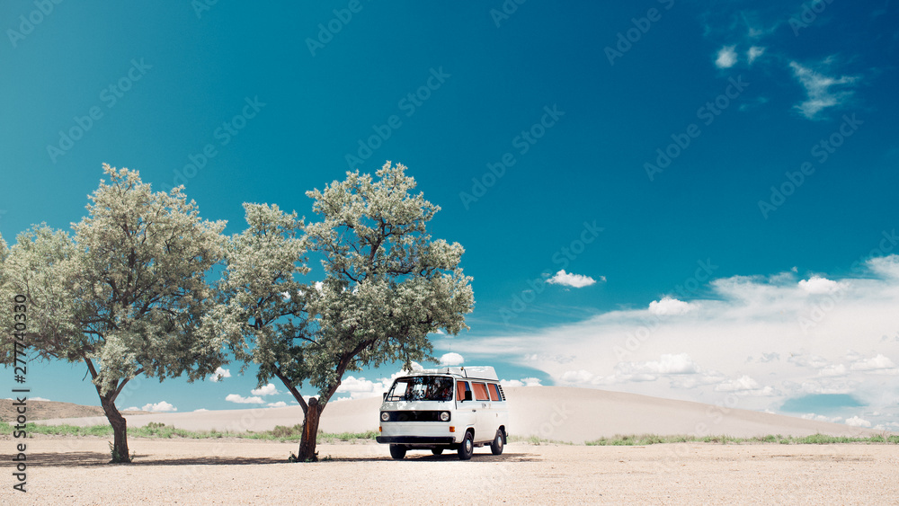 Car getting shade under a tree in the desert with blue sky