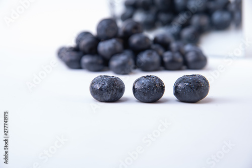 Picture of ripe blueberries - Pile of ripe blueberries in the background - Tasty and ripe wet blueberries on a white table