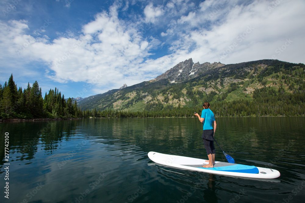 A woman does some SUP (stand up paddle) on Jenny Lake a the Grand Teton National Park. A woman does some SUP (stand up paddle) on Jenny Lake a the Grand Teton National Park.