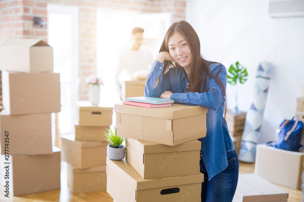 Beautiful young asian couple looking happy, young woman smiling excited moving to a new home Beautiful young asian couple looking happy, young woman smiling excited moving to a new home