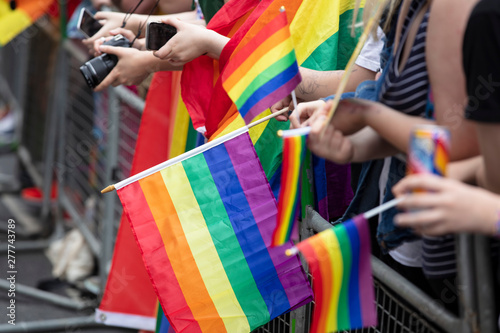 Spectators waves a gay rainbow flag at an LGBT gay pride community event