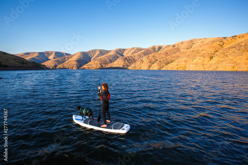 Nate Macconnel and Dora the black lab paddle out on the Snake River during an early morning summer SUP session in southeast Washington. photo