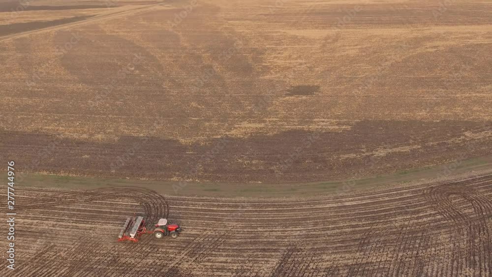 Agronomy and agriculture. Spring field work. Sowing campaign. Agricultural tractor introduces seeds into the soil. Aerial survey, flight of drone Agronomy and agriculture. Spring field work. Sowing campaign. Agricultural tractor introduces seeds into the soil. Aerial survey, flight of drone