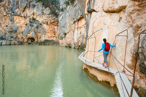 A woman walks by the teal water sof the Charco Azul near Chulilla, Spain.
