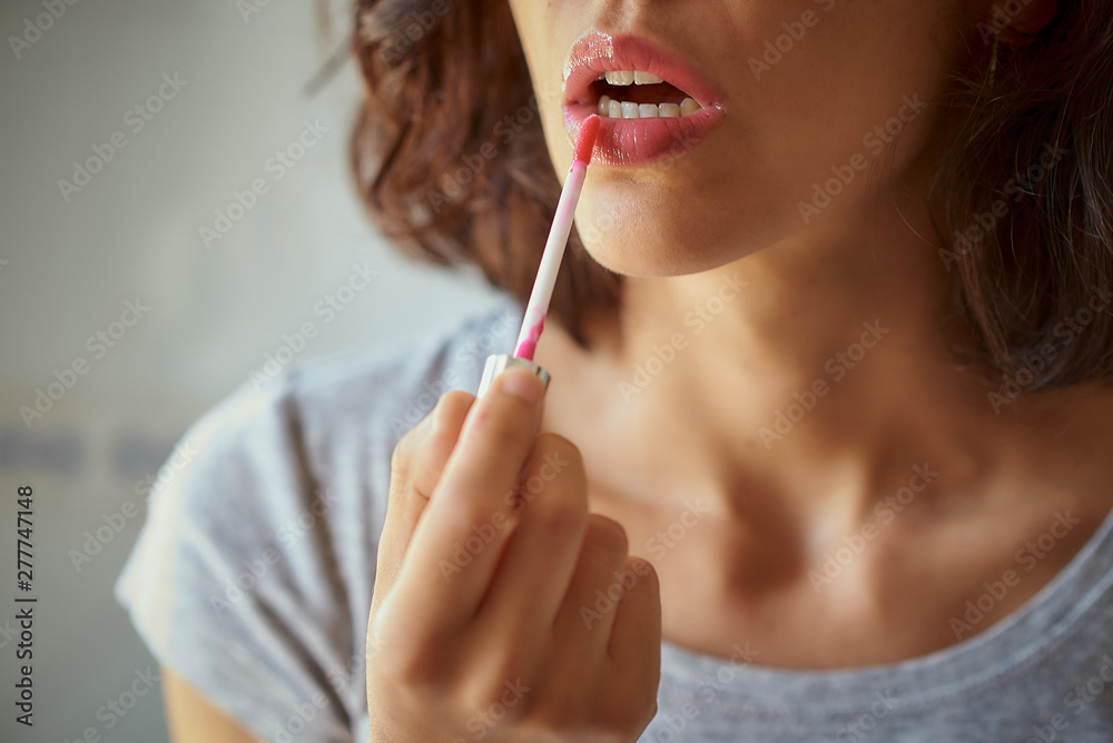 Brunette woman of latin race doing makeup in a mirror. Brunette woman of latin race doing makeup in a mirror.