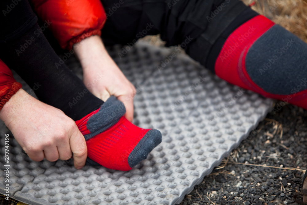 A man puts on a wool sock while preparing for an ice climb at Banks Lake in Washington. A man puts on a wool sock while preparing for an ice climb at Banks Lake in Washington.