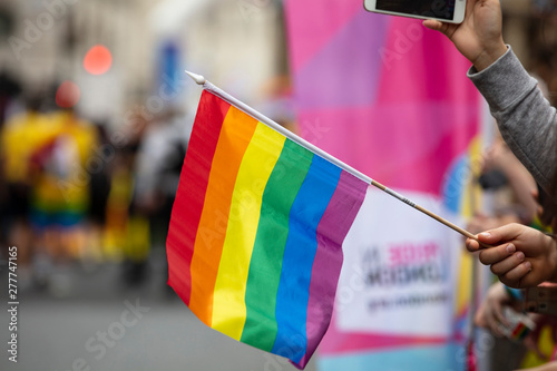 Spectators waves a gay rainbow flag at an LGBT gay pride community event