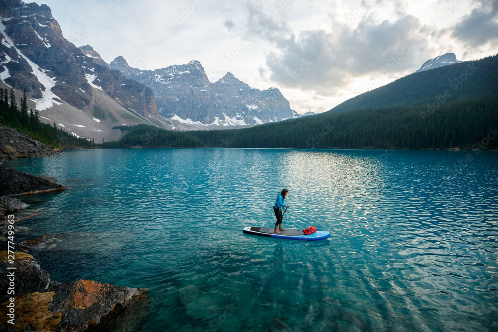Woman paddleboarding in Moraine Lake Woman paddleboarding in Moraine Lake