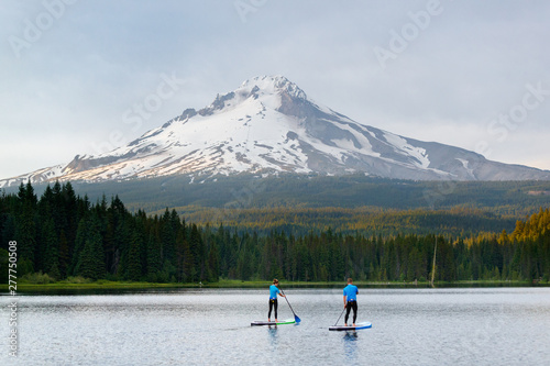 A man and woman stand up paddleboard at Trillium Lake, a popular recreation lake near the base of Mount Hood, Oregon. photo