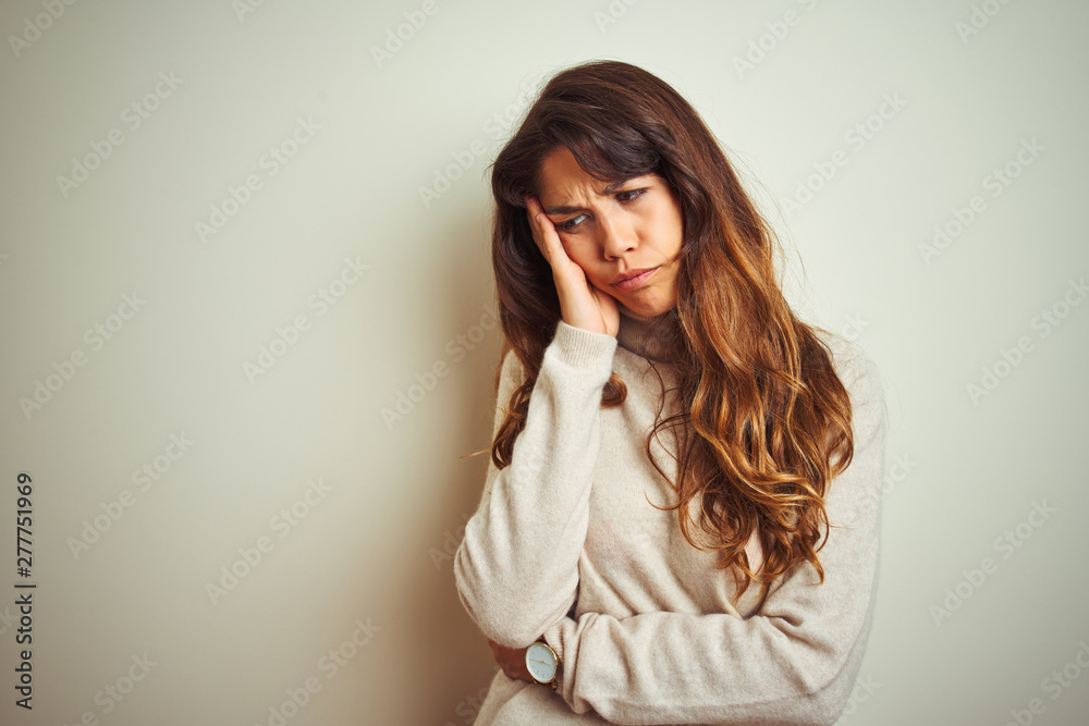 Young beautiful woman wearing winter sweater standing over white isolated background thinking looking tired and bored with depression problems with crossed arms. Young beautiful woman wearing winter sweater standing over white isolated background thinking looking tired and bored with depression problems with crossed arms.
