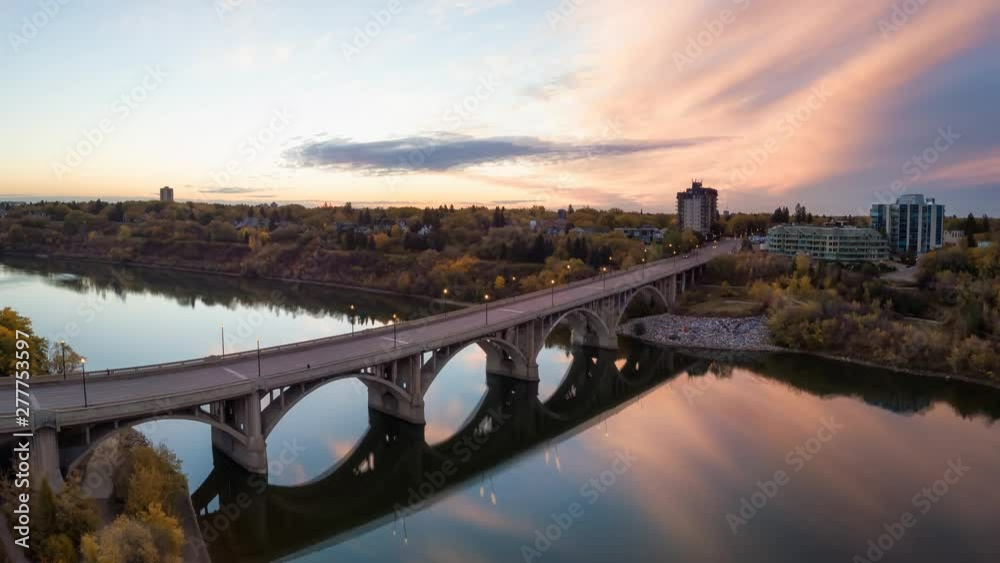 Aerial view of a bridge going over Saskatchewan River during a vibrant sunrise in the Fall Season. Taken in Saskatoon, SK, Canada. Still Image Continuous Animation