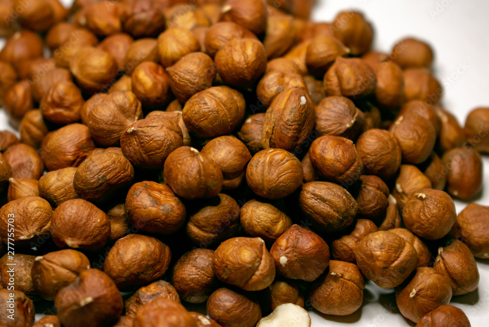 Several varieties of nuts are located on a white sheet of paper. Several varieties of nuts are located on a white sheet of paper.