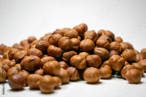 Several varieties of nuts are located on a white sheet of paper.