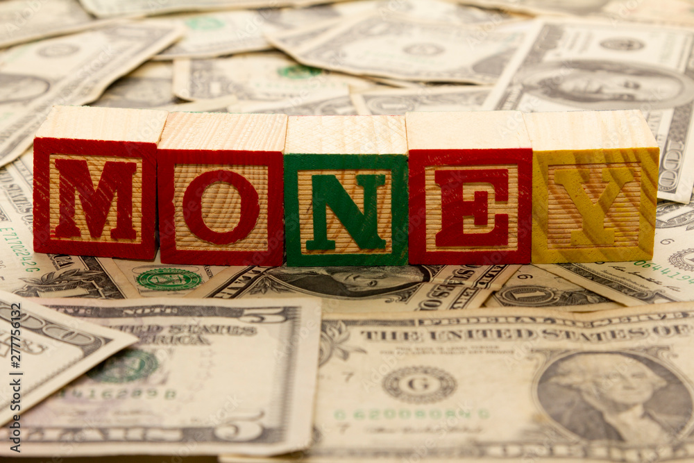Wooden cubes with the word money on dollars. Wooden cubes with the word money on dollars.