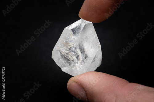 Holding a dob rough diamond formed by volcanic heat and pressure inside the earth