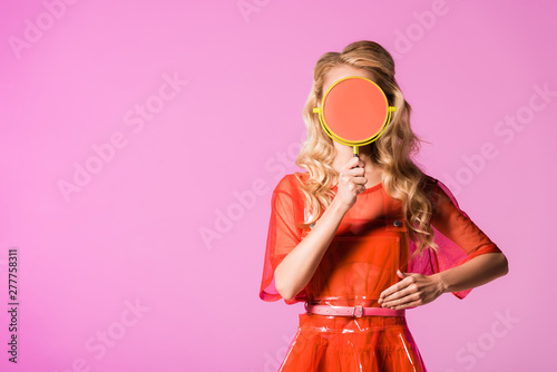 Valokuva girl covering face with hand mirror and posing isolated on pink, doll concept