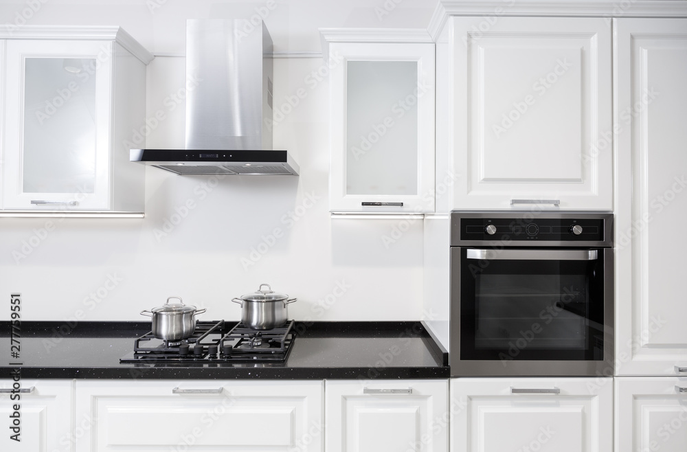 White glossy kitchen furniture with equipment and pots on a cooker - obrazy, fototapety, plakaty 
