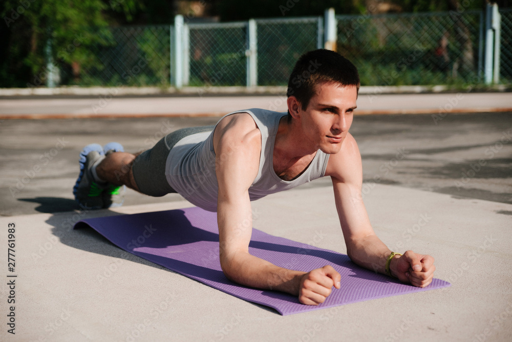 Side view of athlete in sportswear doing plank exercise for abdomen muscles Side view of athlete in sportswear doing plank exercise for abdomen muscles