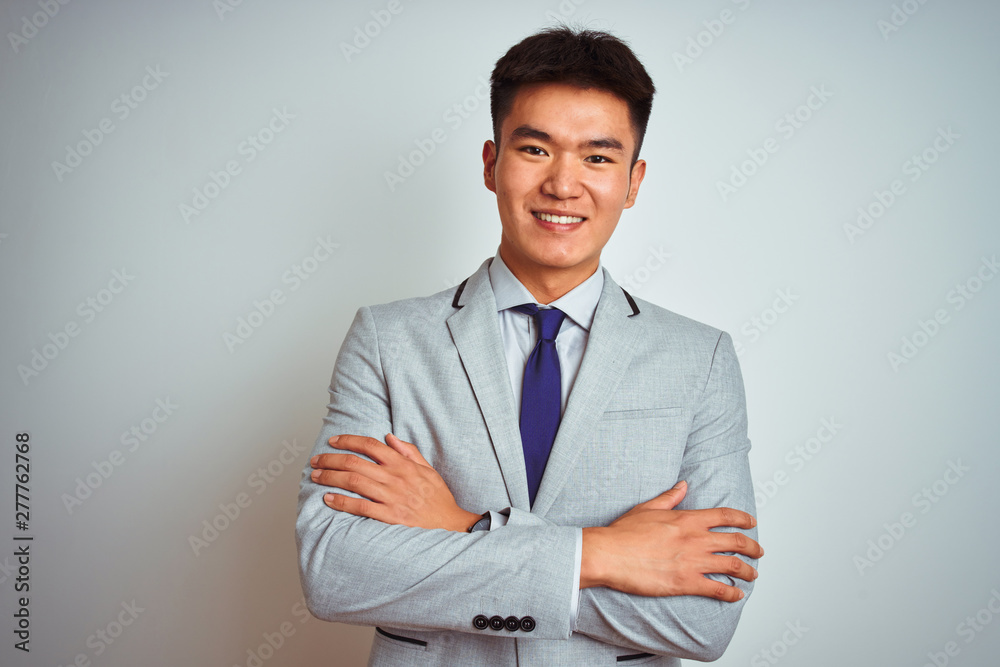 Asian chinese businessman wearing grey jacket and tie standing over isolated white background happy face smiling with crossed arms looking at the camera. Positive person. Asian chinese businessman wearing grey jacket and tie standing over isolated white background happy face smiling with crossed arms looking at the camera. Positive person.
