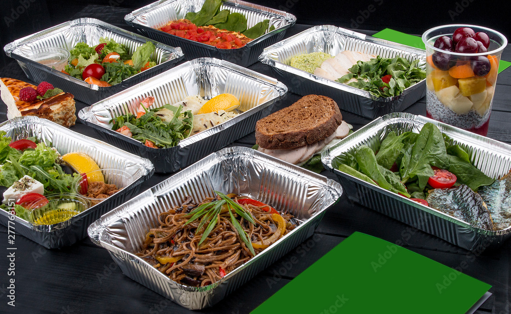 A set of diet dishes in containers on a dark wooden background. Takeaway. Diet and healthy food.