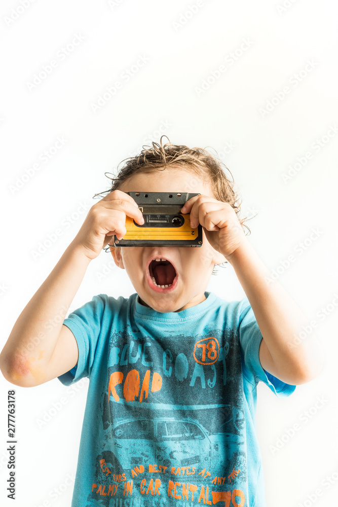 Child looking through the holes of a cassette tape Child looking through the holes of a cassette tape