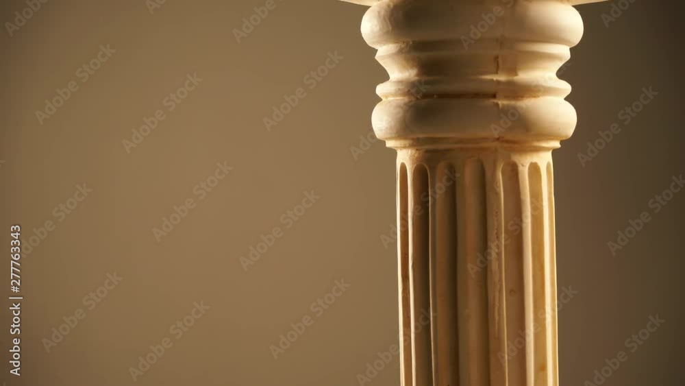 Single ancient greek column rotating slowly on brown background, copy space text area Single ancient greek column rotating slowly on brown background, copy space text area