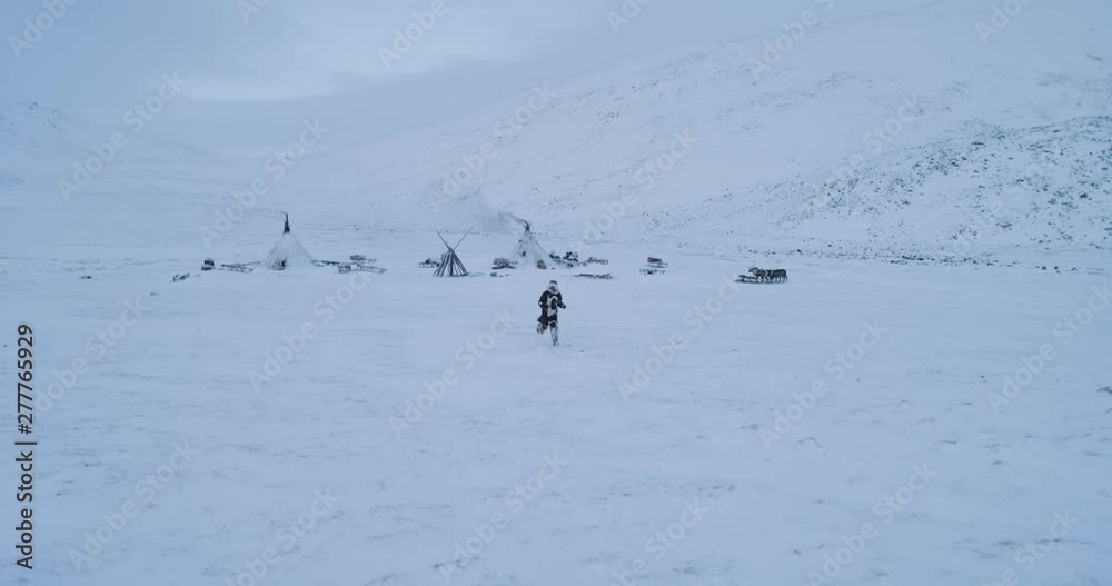 Amazing capturing video of running man in the middle of Siberia , a big camp of yurts and reindeers around. 4k Amazing capturing video of running man in the middle of Siberia , a big camp of yurts and reindeers around. 4k
