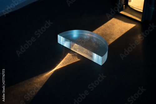 Physics experiment. Lightbeams pass through a positive lens, showing a convergent pattern. Lightbeams come together in focal point.