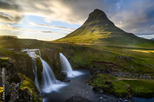 Scenery long exposure shot of Kirkjufell mountain with waterfall on the foreground