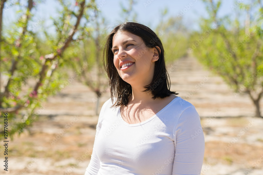 Beautiful young woman smiling cheerful at green trees garden on a sunny day of spring Beautiful young woman smiling cheerful at green trees garden on a sunny day of spring