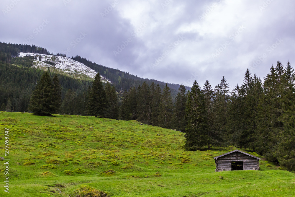 eine Berghütte aus Holz, im Hintergrund Berge