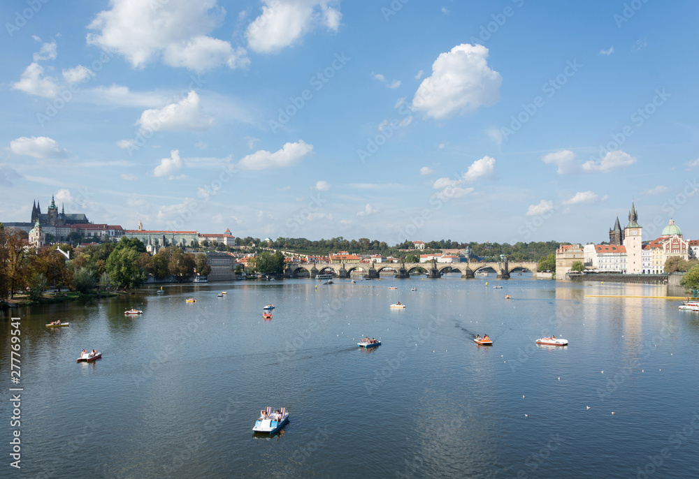 Panoramic view of Vltava river, Prague castle, Charles bridge and colorful rooftops of New Town on a bright summer day, in Prague, Czech Republic