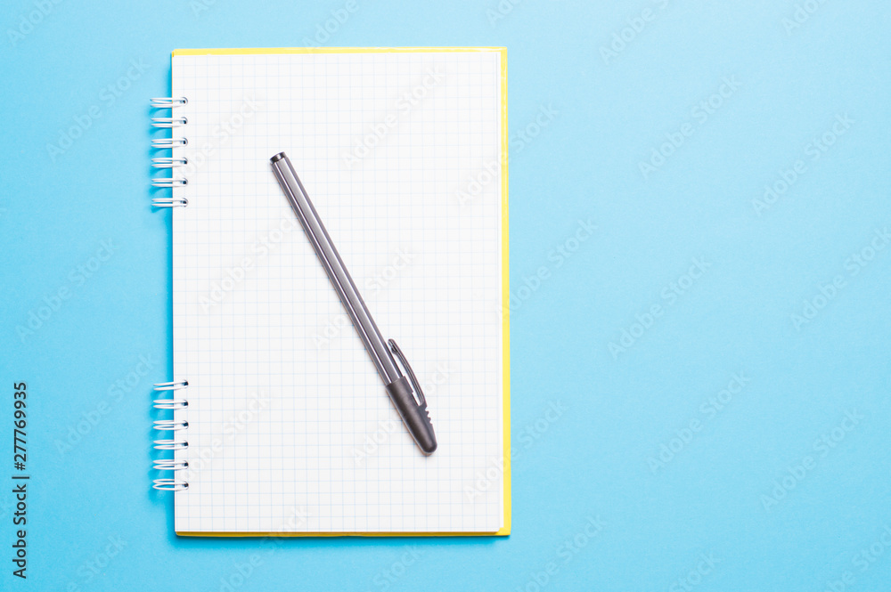 notebook with black pen on blue background notebook with black pen on blue background