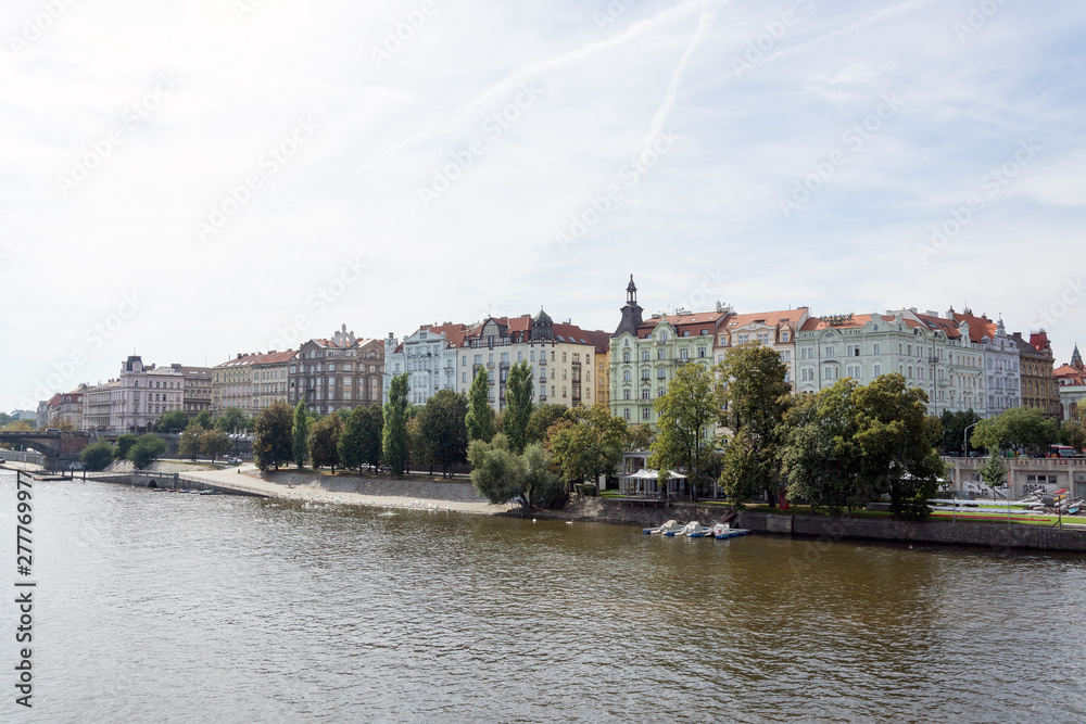 Obraz premium Waterfront panorama of Vltava river, colorful rooftops of New Town buildings on a bright summer day, in Prague, Czech Republic