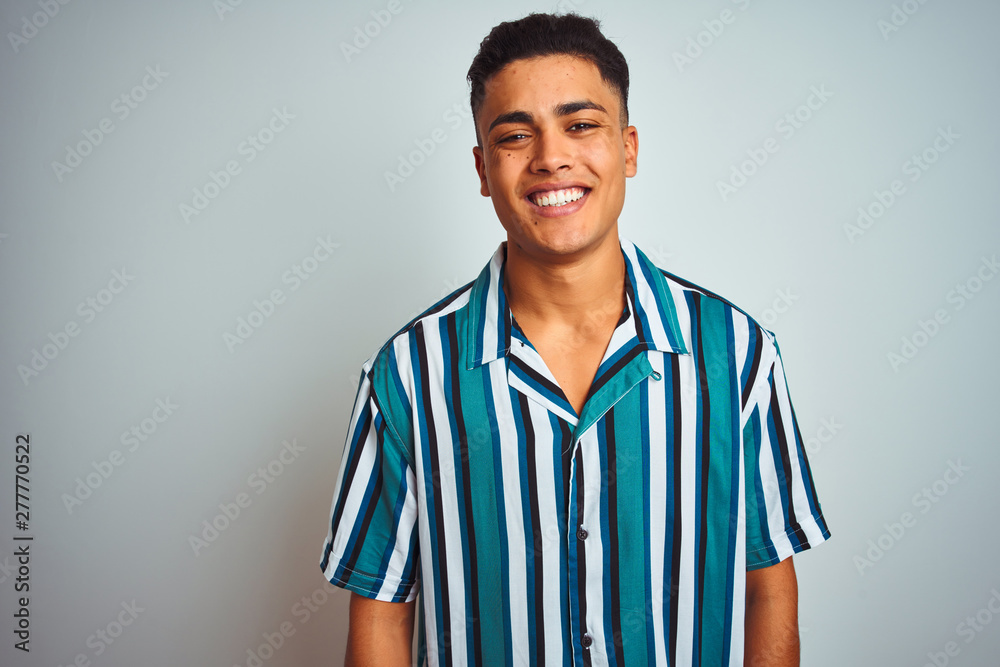 Young brazilian man wearing summer striped shirt standing over isolated white background with a happy and cool smile on face. Lucky person.