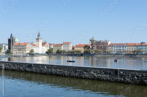 Waterfront panorama of Vltava river, colorful rooftops of Old Town and Charles bridge tower on a bright summer day, in Prague, Czech Republic