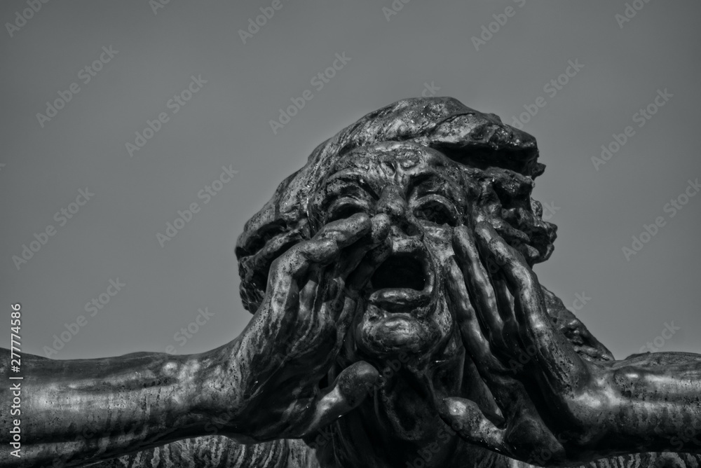Statue with a gesture of call. Head of sculpture with open mouth and hands. Background of pure sky. Black and white photo.