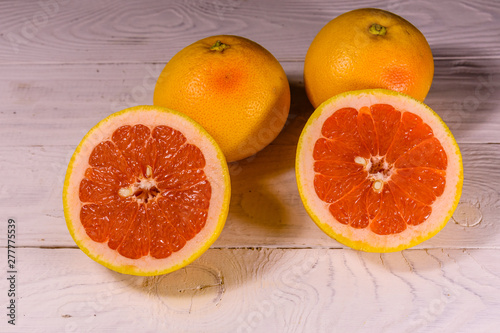 Ripe juicy grapefruit on a white wooden table