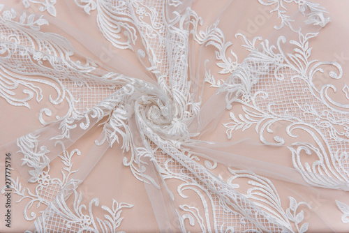 a background image of ivory-colored lace cloth. White lace on beige background.