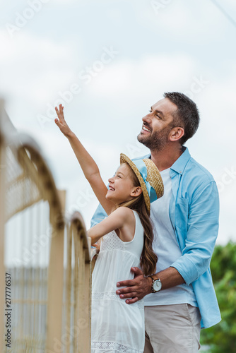 cheerful kid gesturing standing standing with happy man